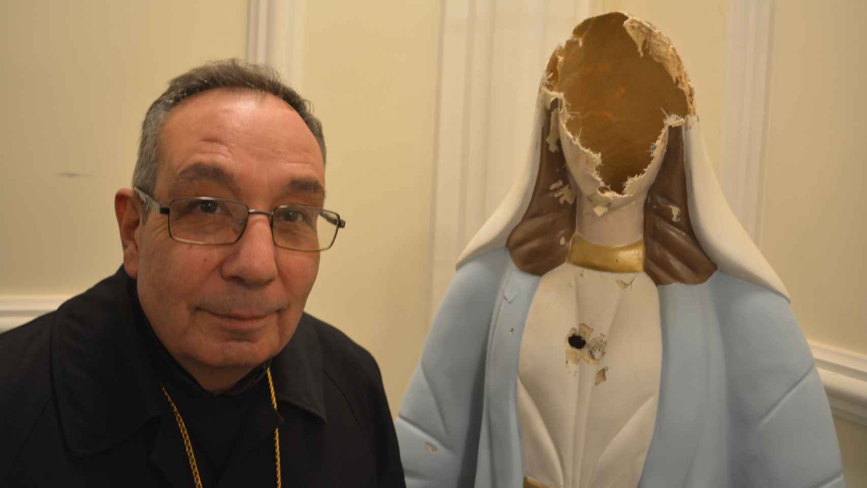 Monseñor Arbach posa junto a una figura de la virgen María destrozada en Homs (Siria).