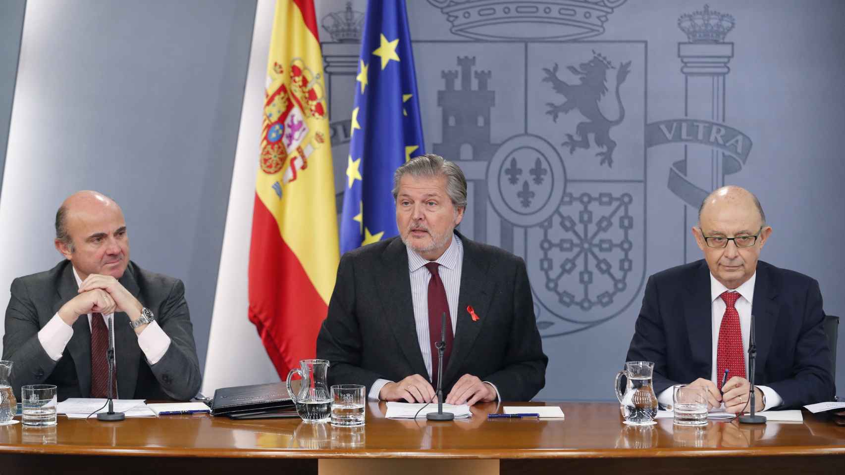 El portavoz del Gobierno, Íñigo Méndez de Vigo (c), junto al ministro de Economía, Industria y Competitividad, Luis de Guindos (i), y el ministro de Hacienda, Cristóbal Montoro (d).