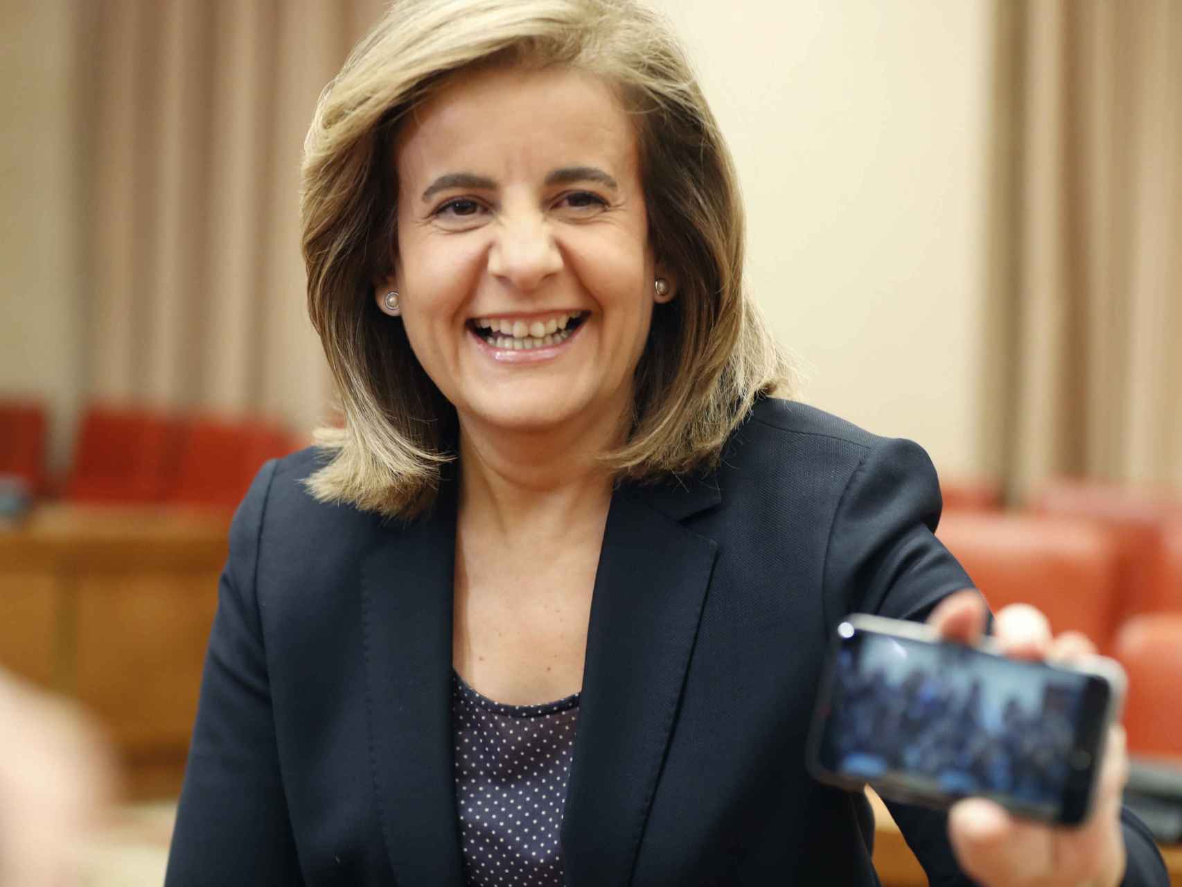 La ministra Fátima Báñez enseña una imagen a los fotógrafos.