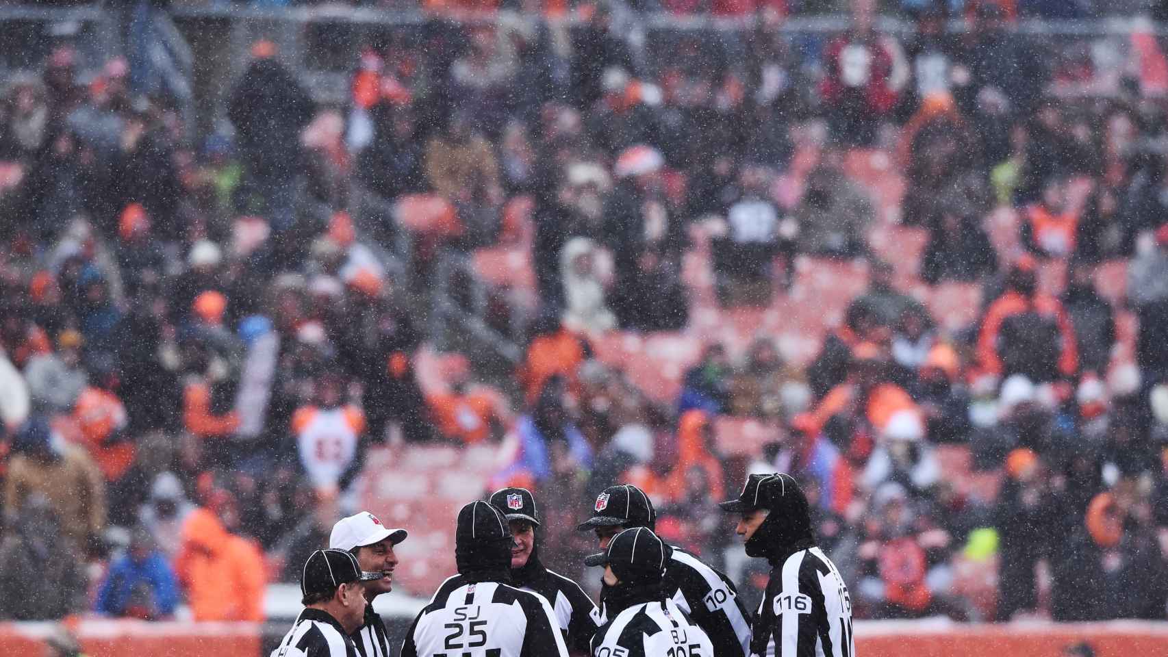 Varios árbitros tratan de tomar una decisión en un partido de la NFL.