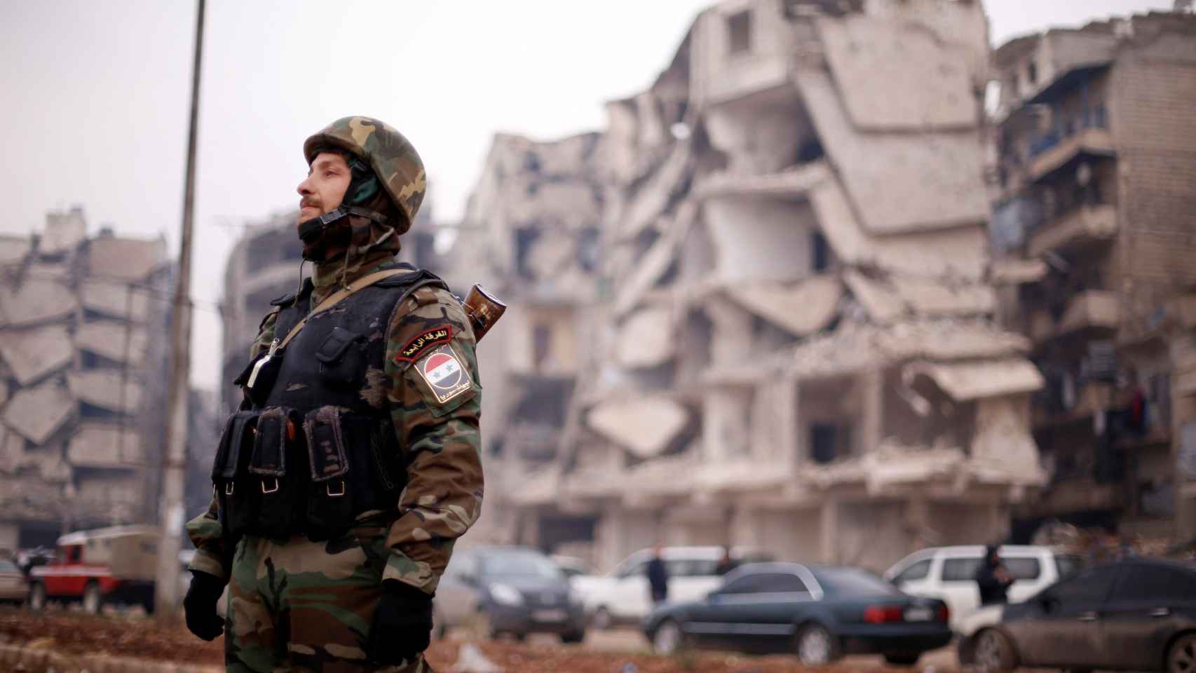 Un soldado de las fuerzas leales a Asad, cerca de edificios dañados en Alepo.
