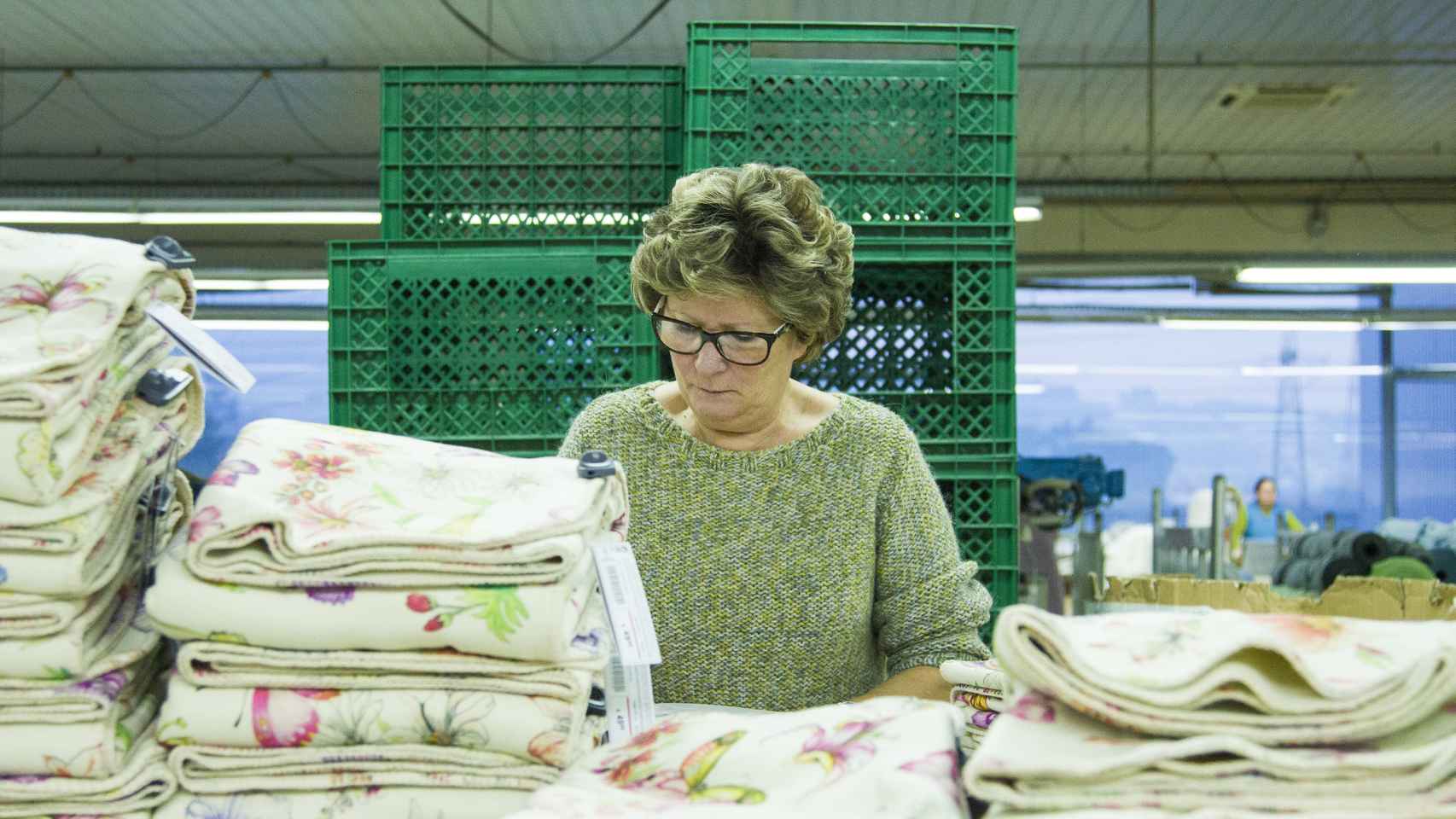 Una trabajadora de Crispim Abreu dobla mantas que se venderán en Zara Home.