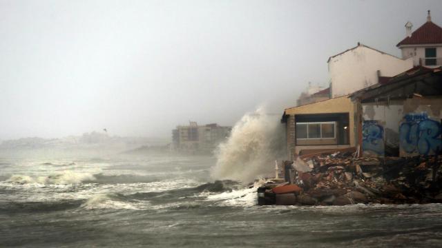 Las olas rompen sobre una casa junto a la playa en Guardamar del Segura (Alicante)