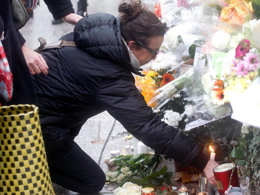 Una mujer deja un recuerdo a las víctimas del atentado.