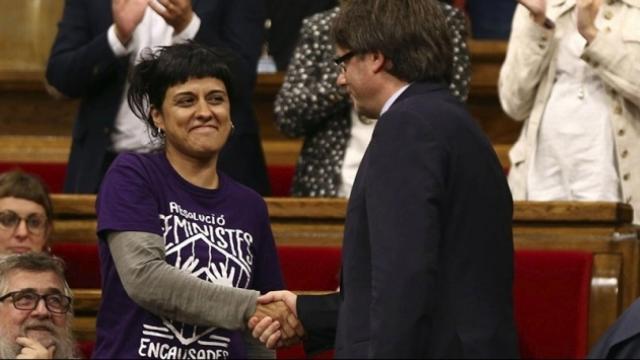 El presidente catalán, Carles Puigdemont, saluda a la diputada de la CUP Anna Gabriel en el 'Parlament'.