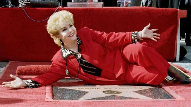 La actriz Debbie Reynolds posando al descubrir su estrella en el paseo de la fama de Hollywood.