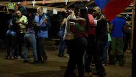 Imagen de los dos observadores bailando con guerrilleras de las FARC.