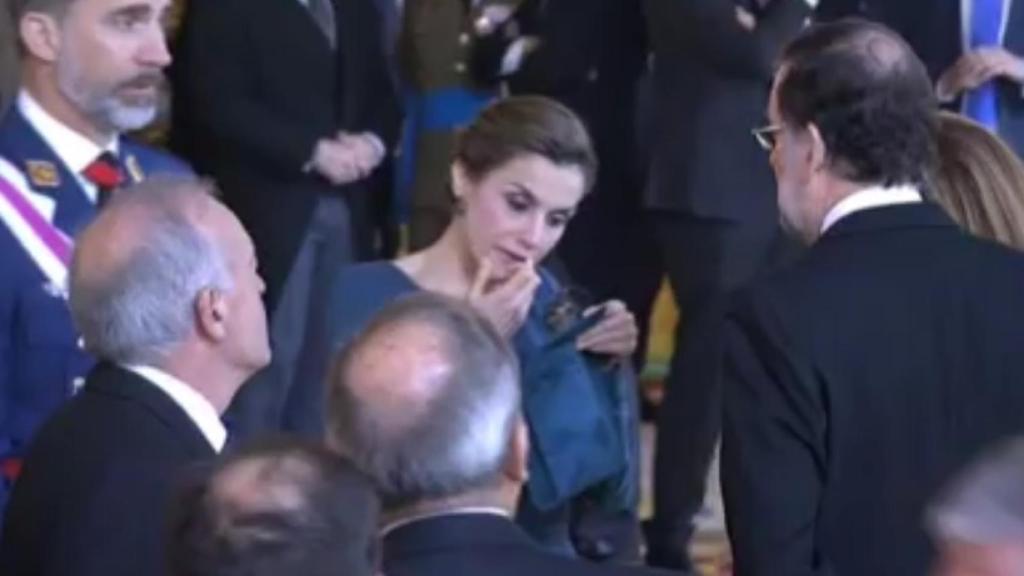 La reina Letizia se retoca con la ayuda de un espejo de bolsillo.