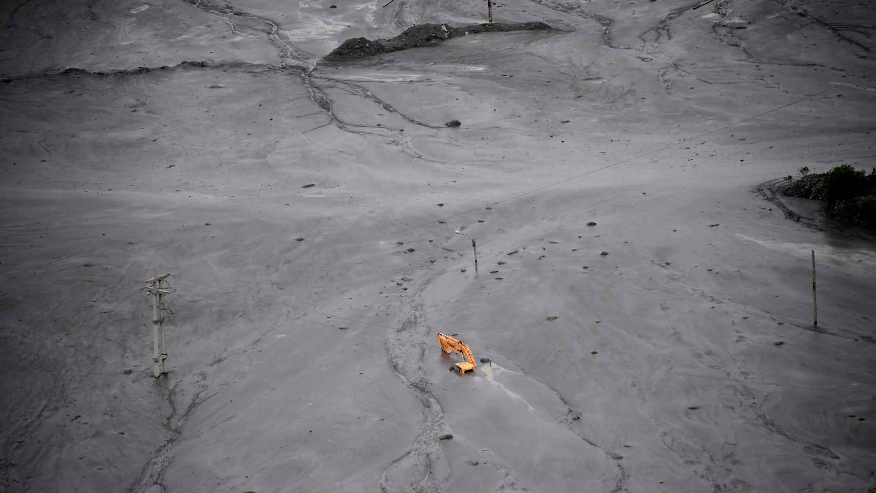 Una grúa, sepultada por el lodo en la localidad de Volcán.