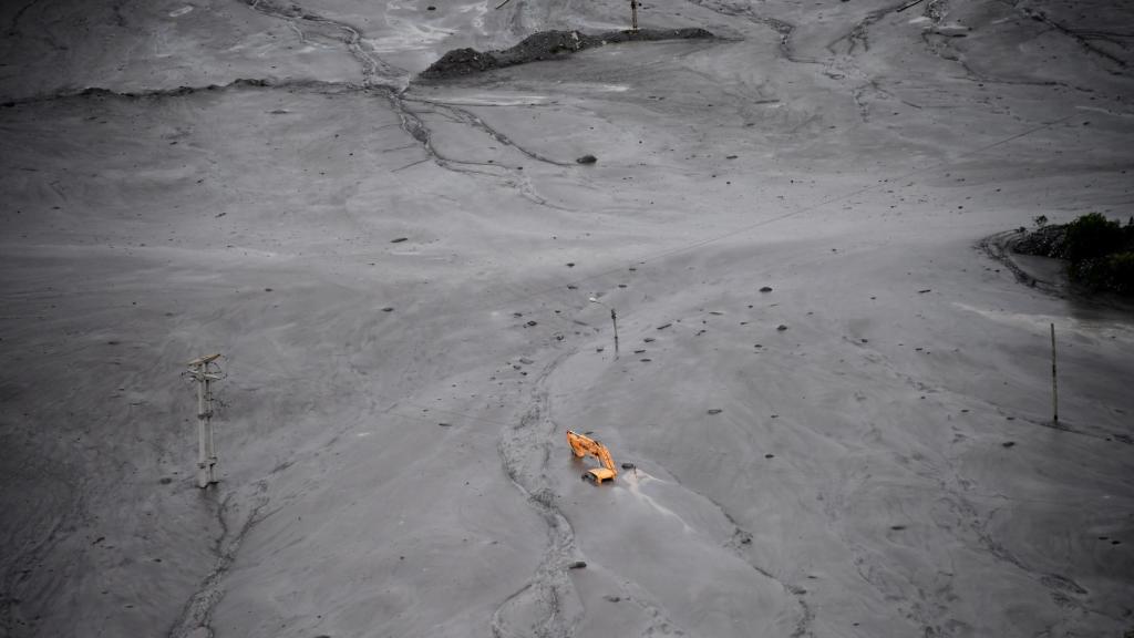 Una grúa, sepultada por el lodo en la localidad de Volcán.