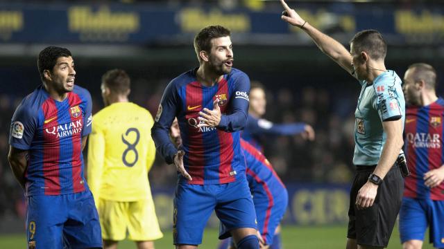 Piqué protesta una acción a un árbitro.