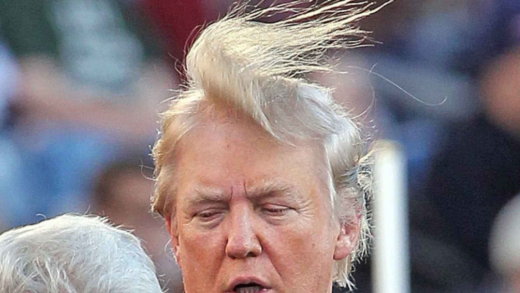 Trump lleva el pelo largo, como se aprecia en esta imagen en la que el viento se lo remueve