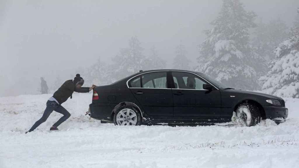 Una persona empuja un coche atrapado en el Alto de El Perdón en Navarra.