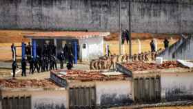 Un grupo de presos es custodiado por la Policía en la prisión de Alcaçuz, este domingo.