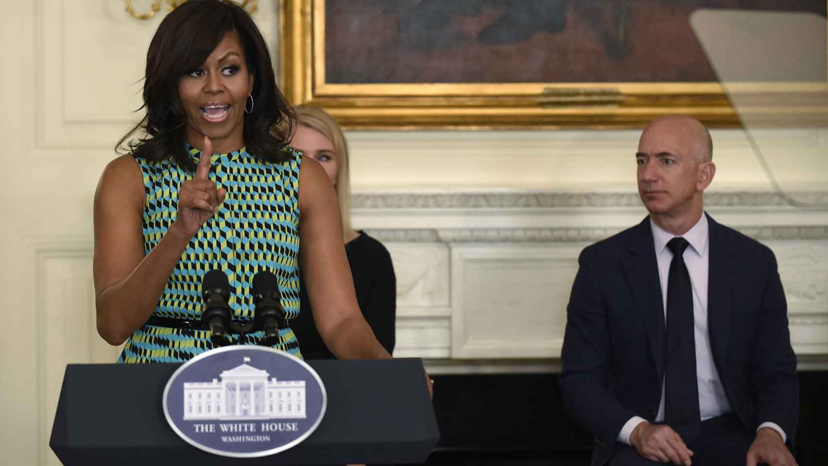 Jeff Bezos atiende a las explicaciones de Michelle Obama, de quien será vecina.