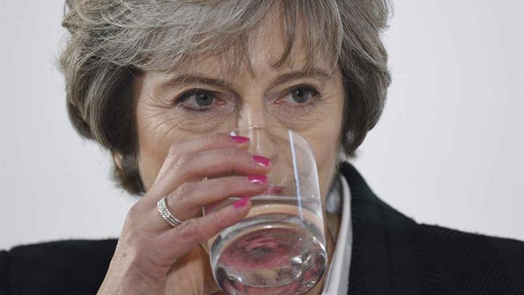 Theresa May bebe un trago de agua durante la presentación de su plan para el brexit.