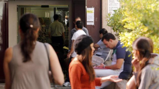 Jóvenes en el exterior de una oficina de empleo.