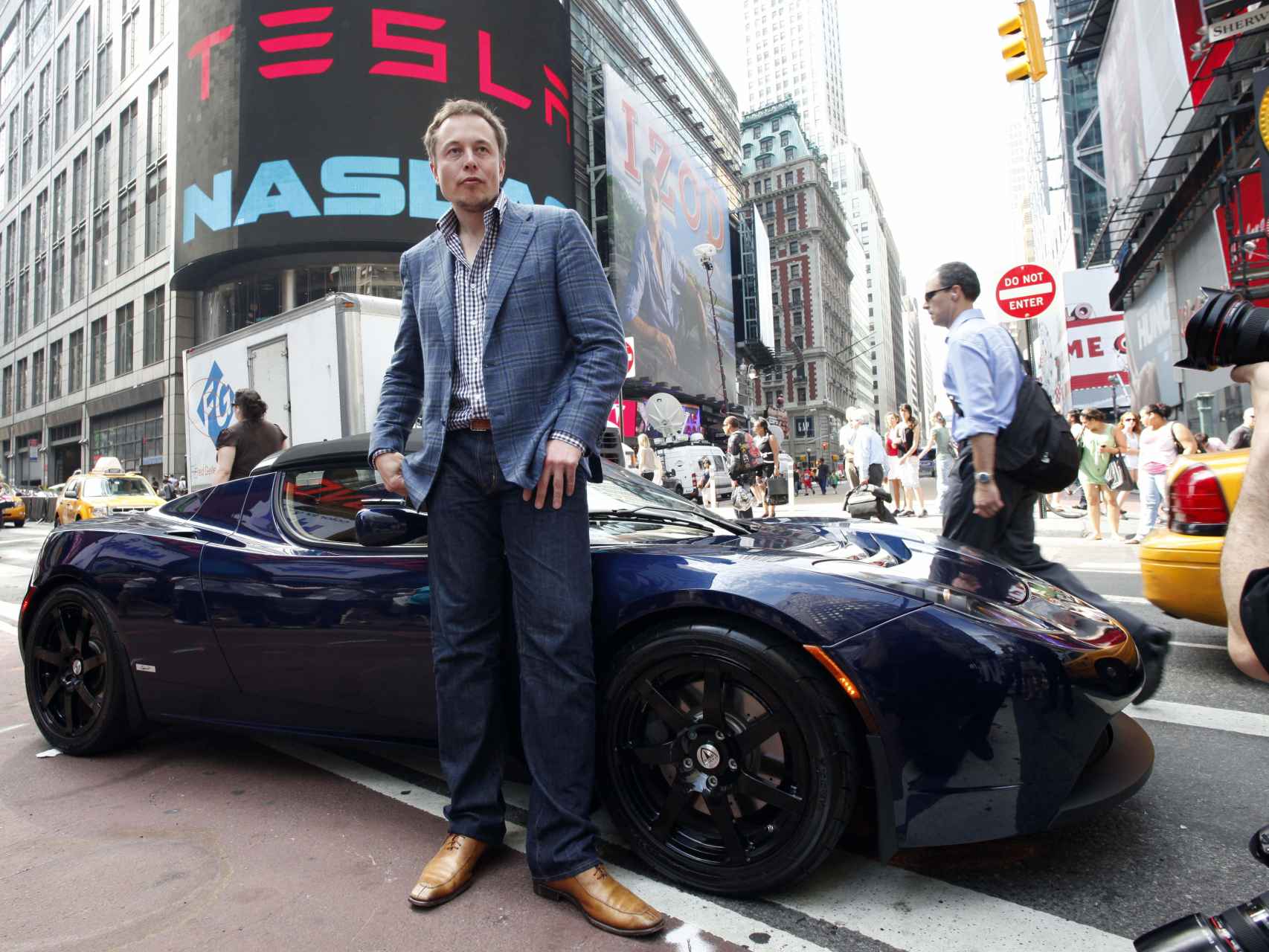 El empresario junto a uno de sus coches de lujo posando para la prensa.