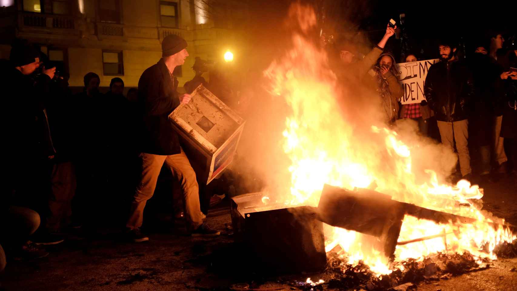 Varios manifestantes hacen un fuego como señal de protesta.