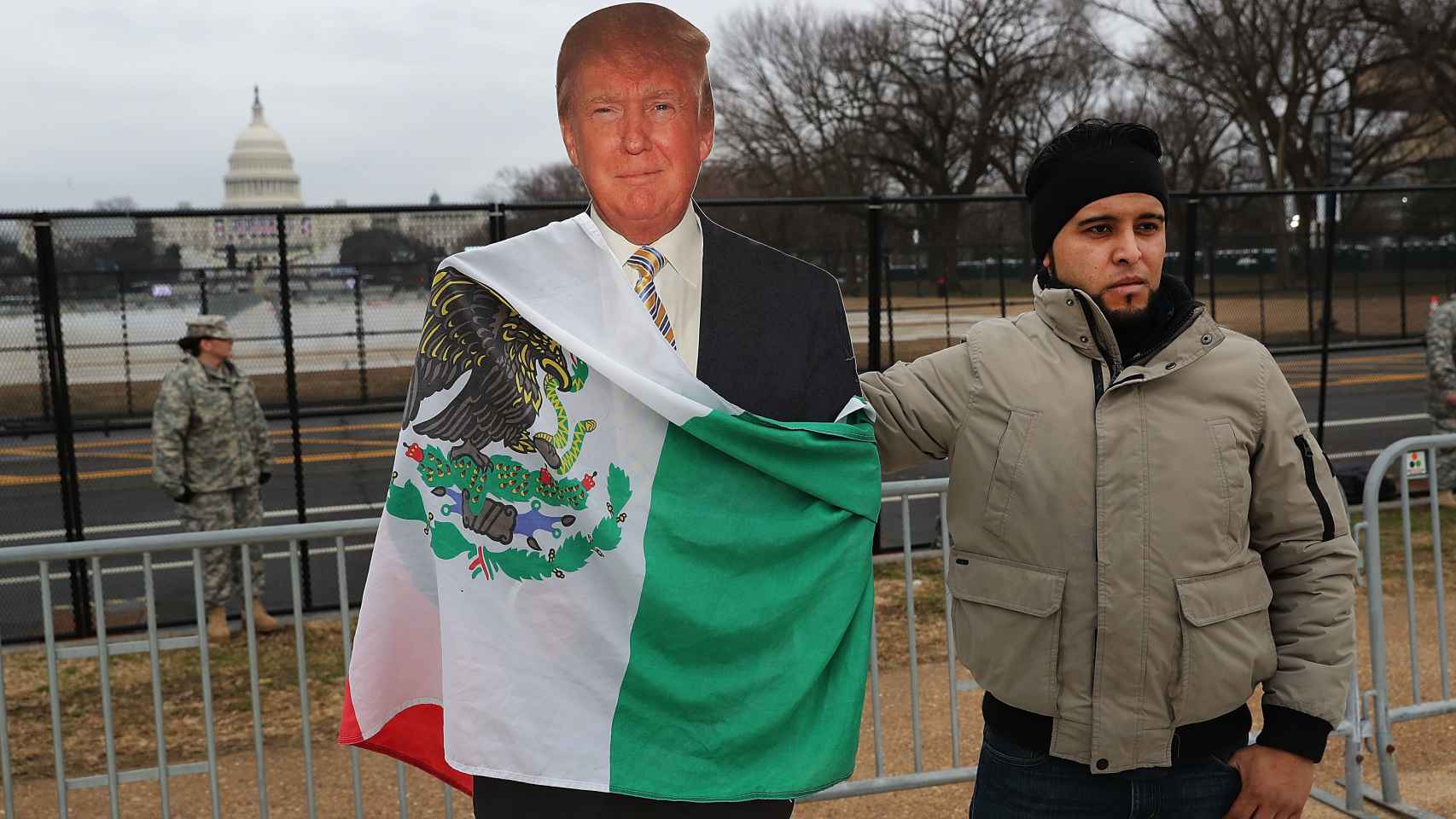 Un activista mexicano pone la bandera de su país sobre una figura de Trump el día de su investidura.