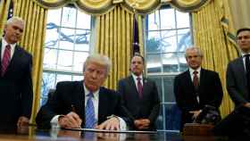 Trump firma la salida del TPP en el despacho Oval.