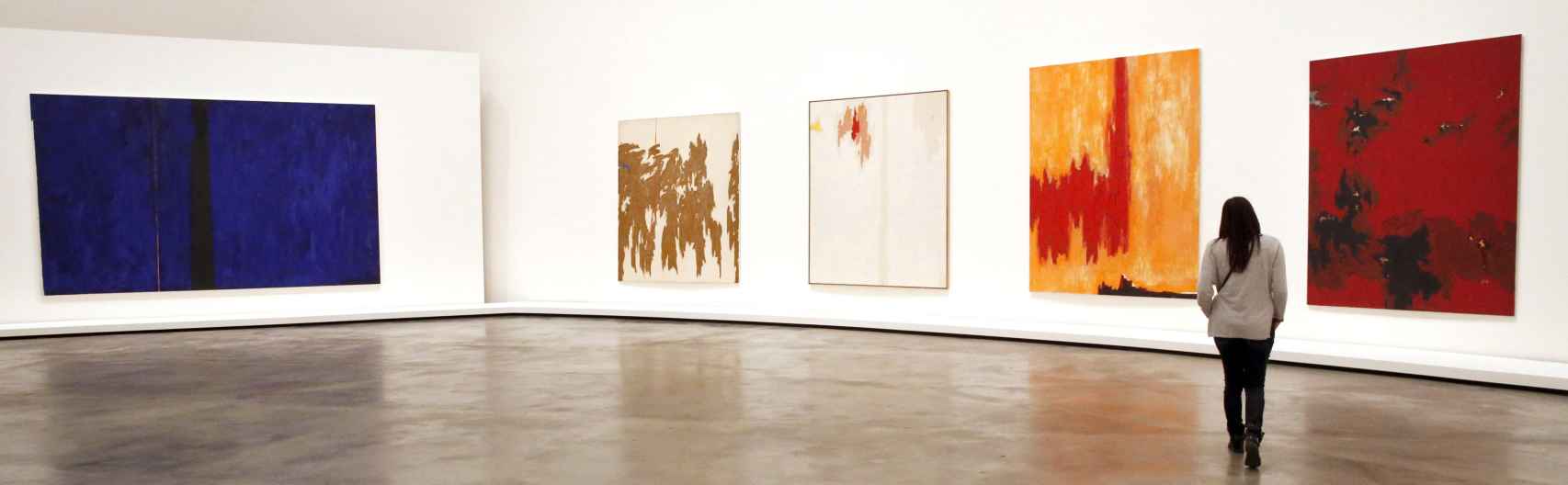 na mujer observa algunas de las obras que componen la exposición Expresionismo Abstracto.
