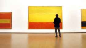 Una persona observa algunas de las obras de Mark Rotho, incluidas en la exposición Expresionismo Abstracto.