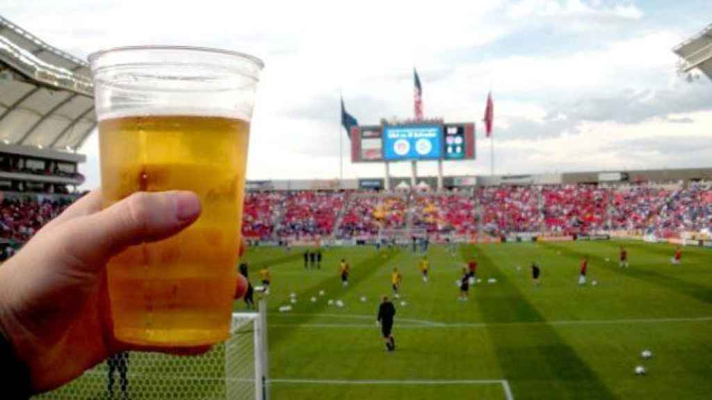 Un aficionado bebe una cerveza en un estadio de fútbol en Inglaterra.