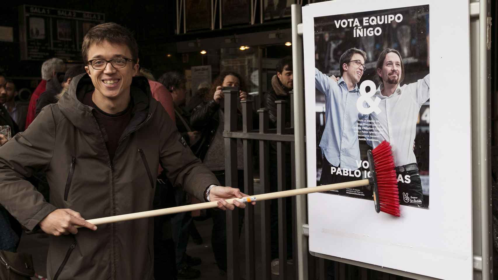Íñigo Errejón pegando el cartel de su campaña, en el que cuenta con Pablo Iglesias.