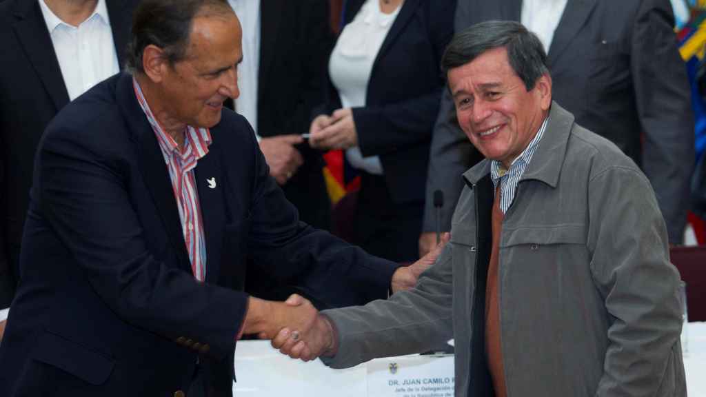 Los representantes del Gobierno y el ELN, Juan Camilo Restrepo y Pablo Beltrán, se estrechan la mano.