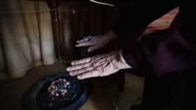 Una mujer se calienta las manos en un brasero de picón en Sevilla