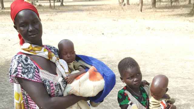 Nyayolah posa con sus hijos en un lugar seguro lejos de casa en Sudán del Sur.