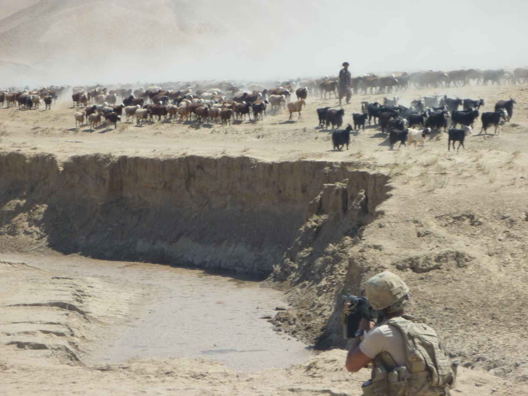 Un soldado español controla los movimientos de un pastor pastún junto al lugar del accidente.
