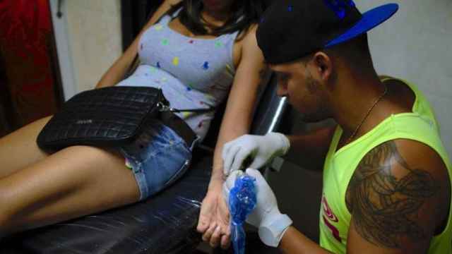 Un tatuador cubano trabaja en su estudio semiclandestino en La Habana.