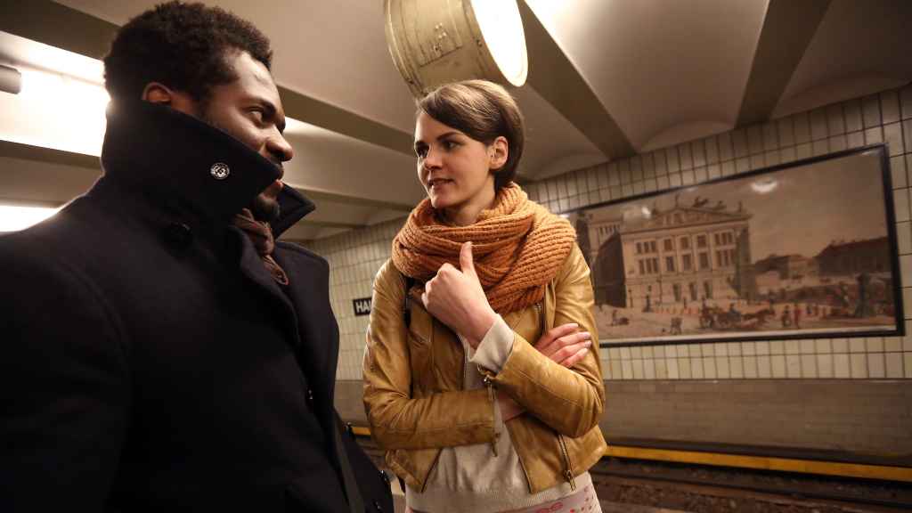 Un chico y una chica se miran en el metro de Berlín.
