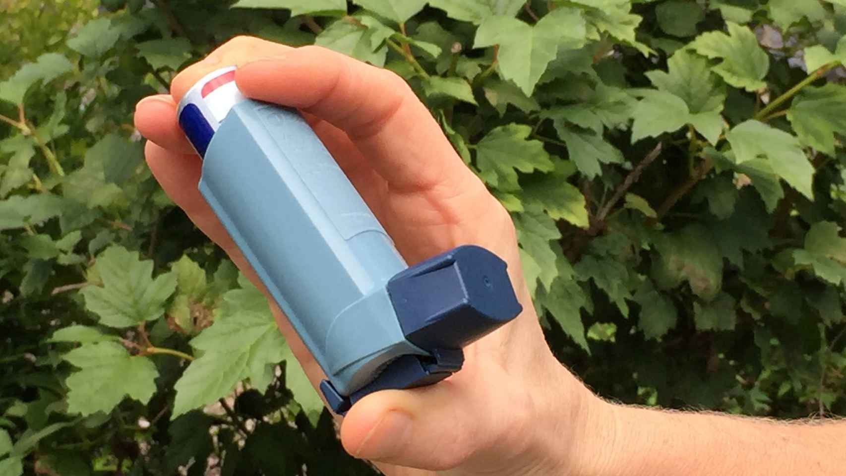 Una persona sostiene su inhalador para el asma.