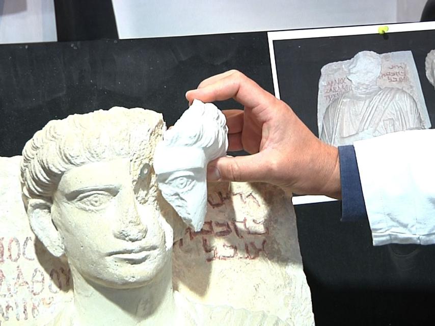 Uno de los arqueólogos muestra la reparación de uno de los dos relieves.