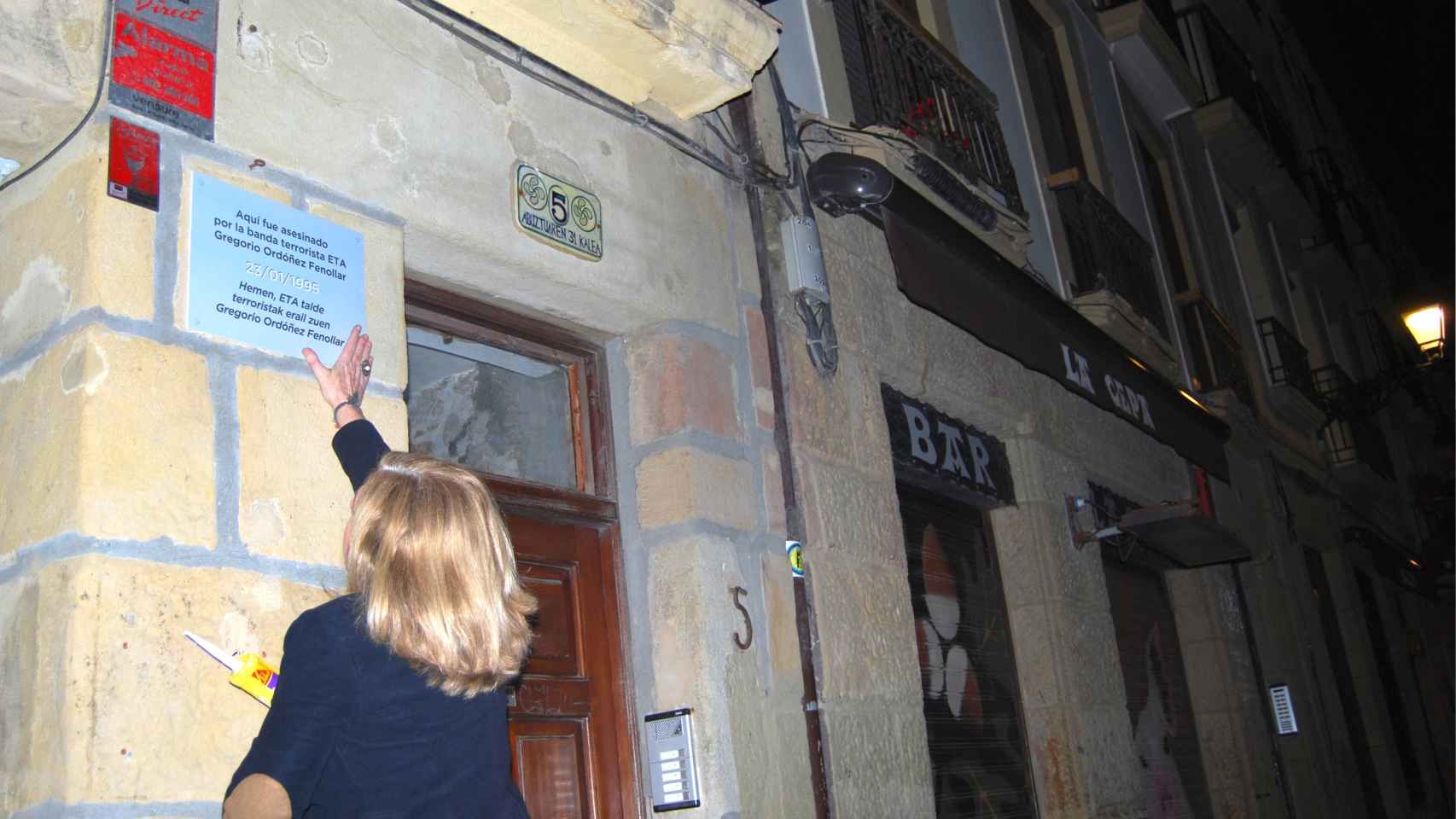Consuelo Ordóñez, presidenta de Covite, coloca la placa que hace referencia a su hermano Gregorio, en San Sebastián.