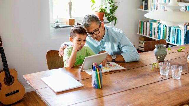 Un niño con su padre usando un producto de Google.