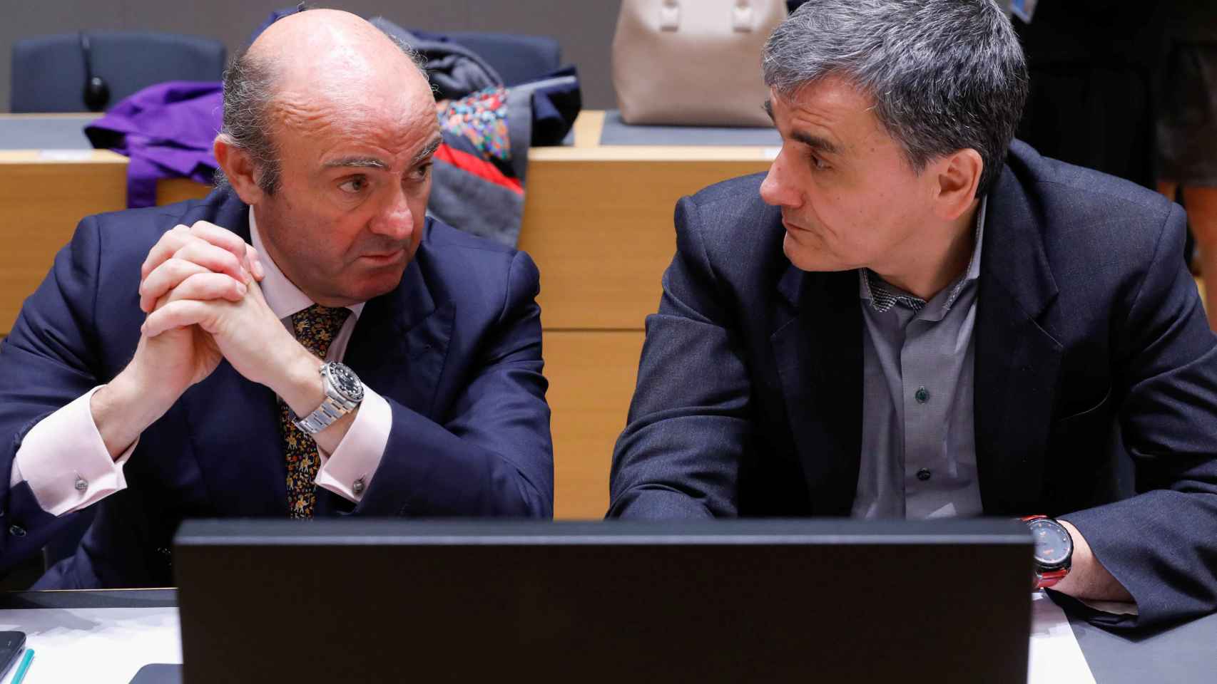 Guindos conversa con su colega griego durante el Eurogrupo