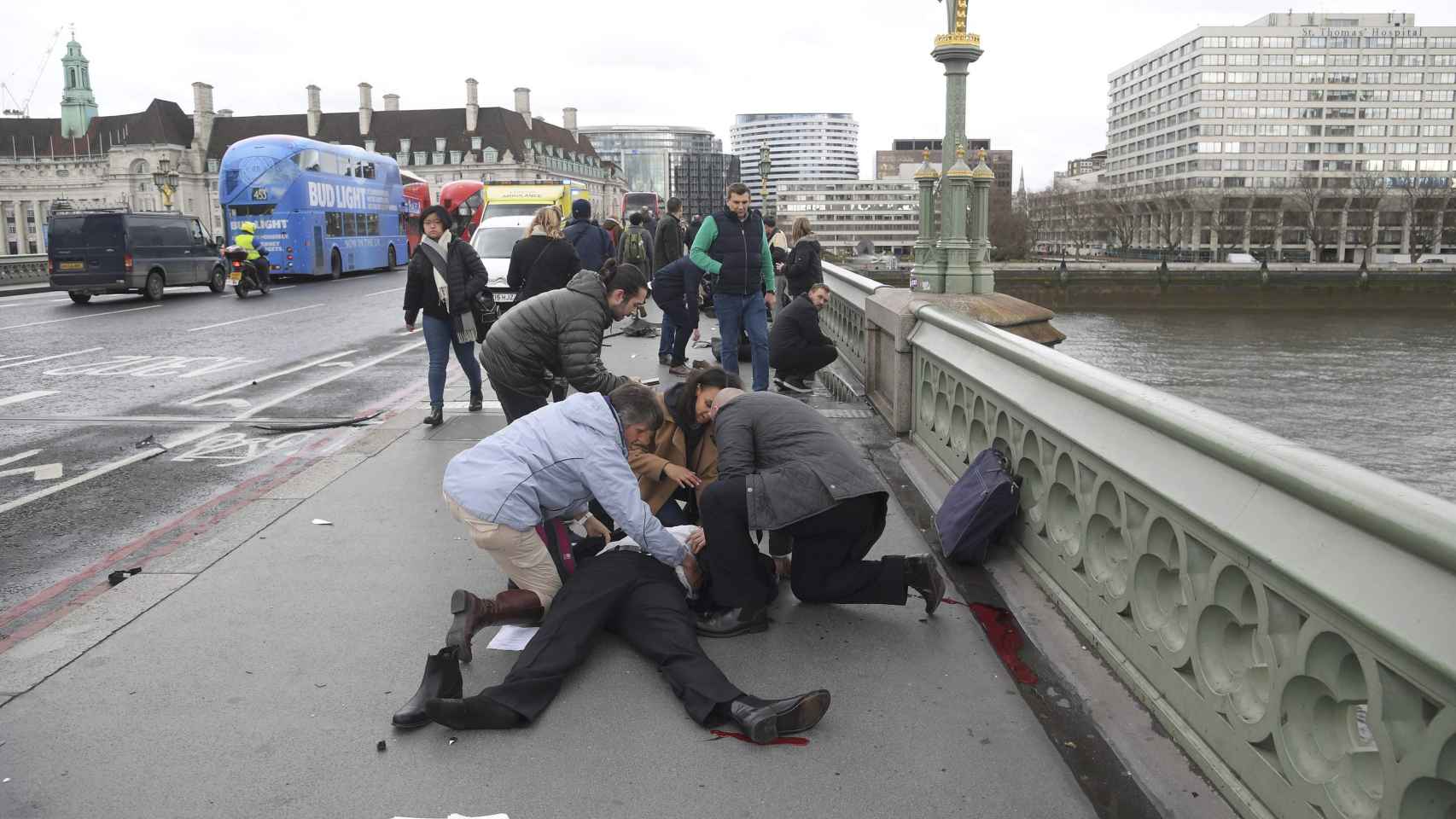 Varias personas atienden a uno de los heridos en el puente de Westminster