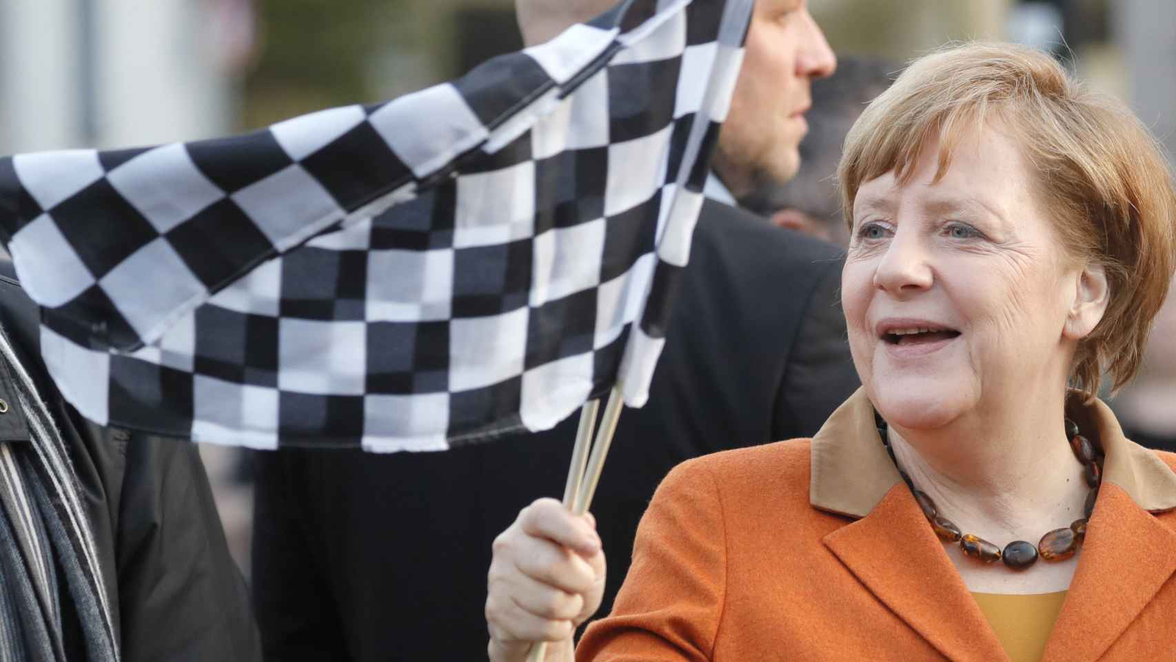 La canciller alemana, Angela Merkel, ondea una bandera durante un acto de campaña del CDU