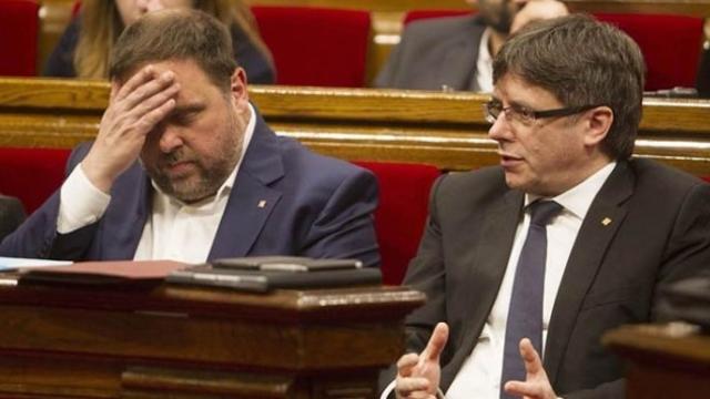 El presidente de la Generalitat, Puigdemont (d) y el vicepresidente económico, Junqueras (i) en el Parlament.