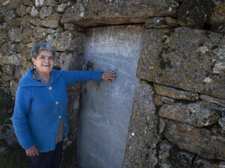 Teresa Alves señala una de las puertas que se construyeron con el fuselaje. Tras ella tiene jamones curándose.