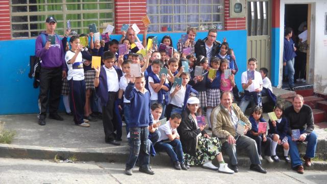 José Alberto Gutiérrez, en el centro, rodeado de niños con libros frente a su casa.