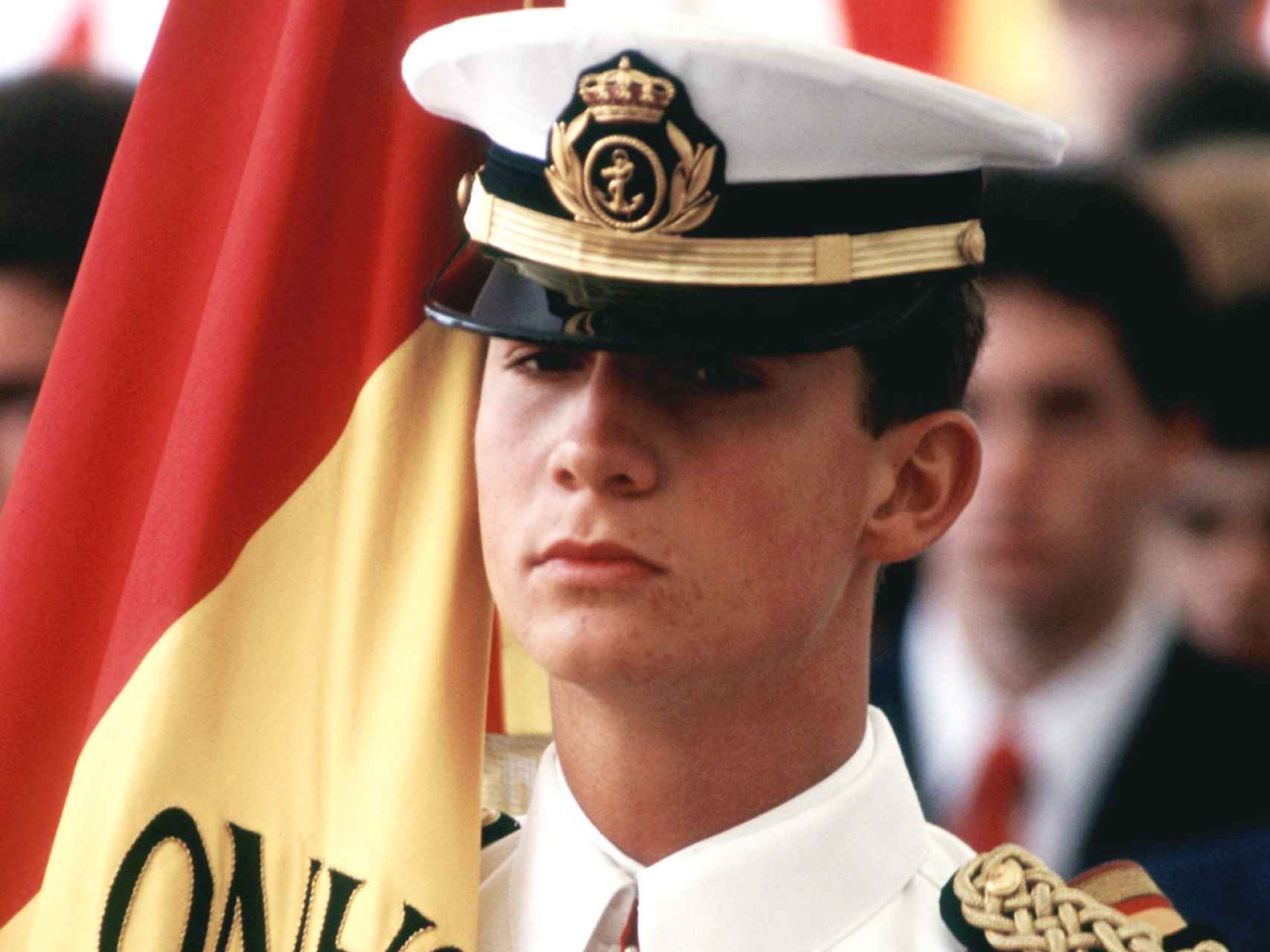El entonces príncipe con uniforme de cadete y la bandera del buque Juan Sebastián Elcano durante un acto oficial.