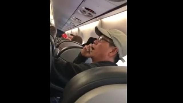 El doctor David Dao habla por teléfono y trata de convencer a los agentes de que tiene que volar en ese avión.