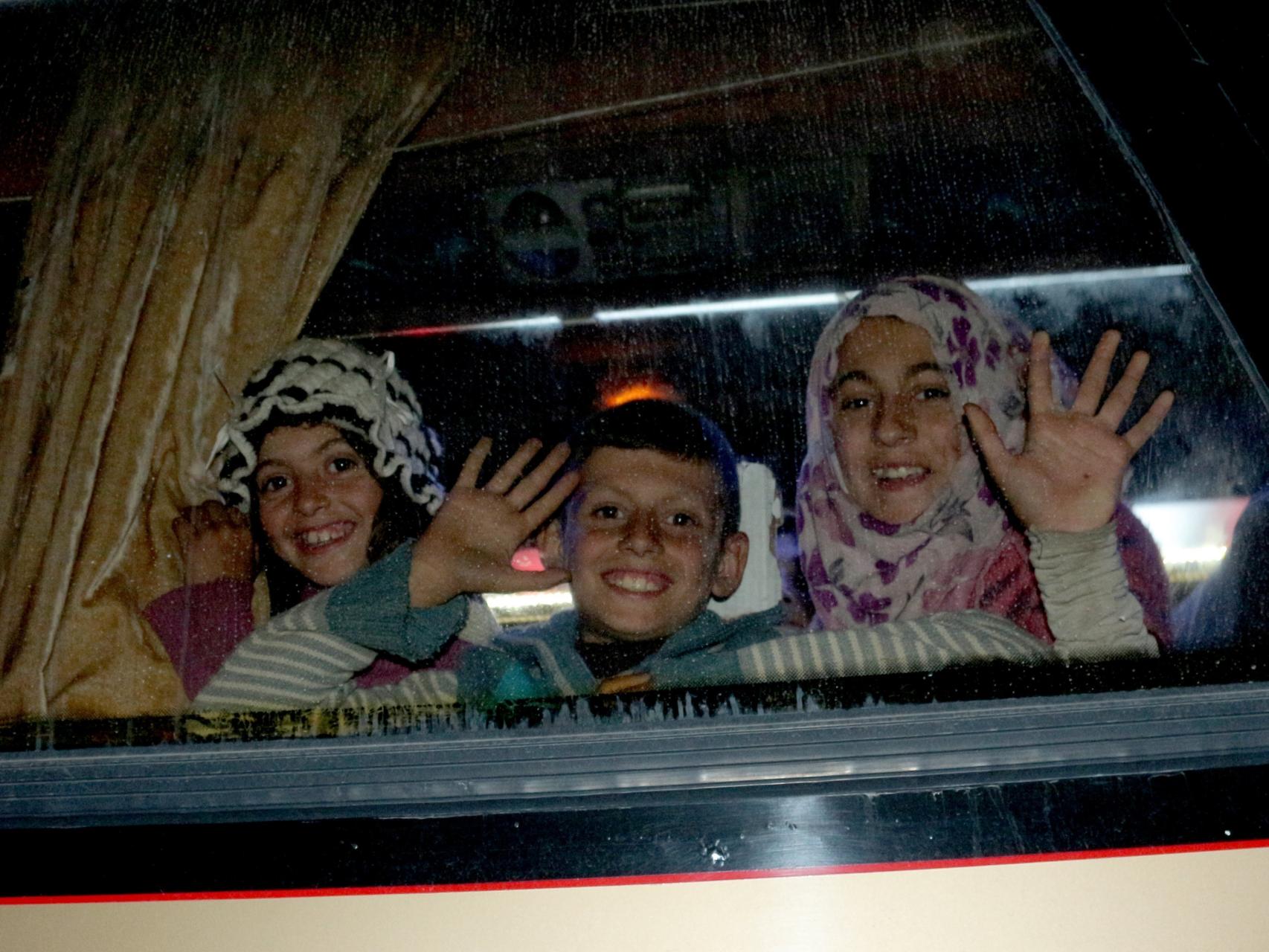 Un grupo de niños espera este sábado a ser evacuado de las inmediaciones de Alepo.
