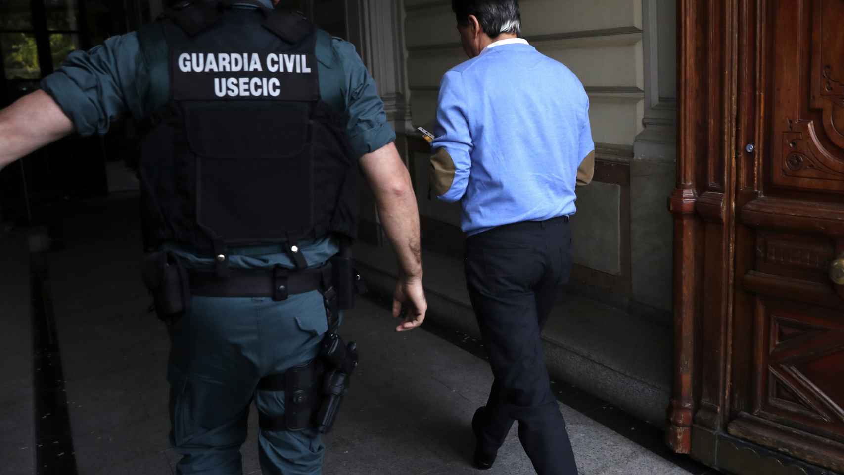 Ignacio González acompañado por los agentes al despacho que tiene en la calle Alcalá