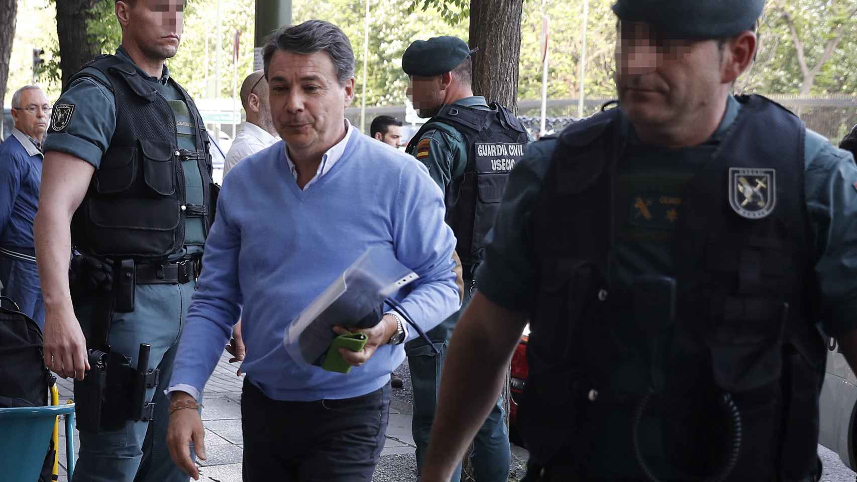 Ignacio González acompañado por varios agentes durante el registro en su oficina